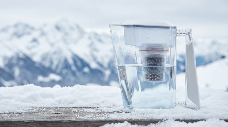 Kini water filter jug in front of snow-covered mountains